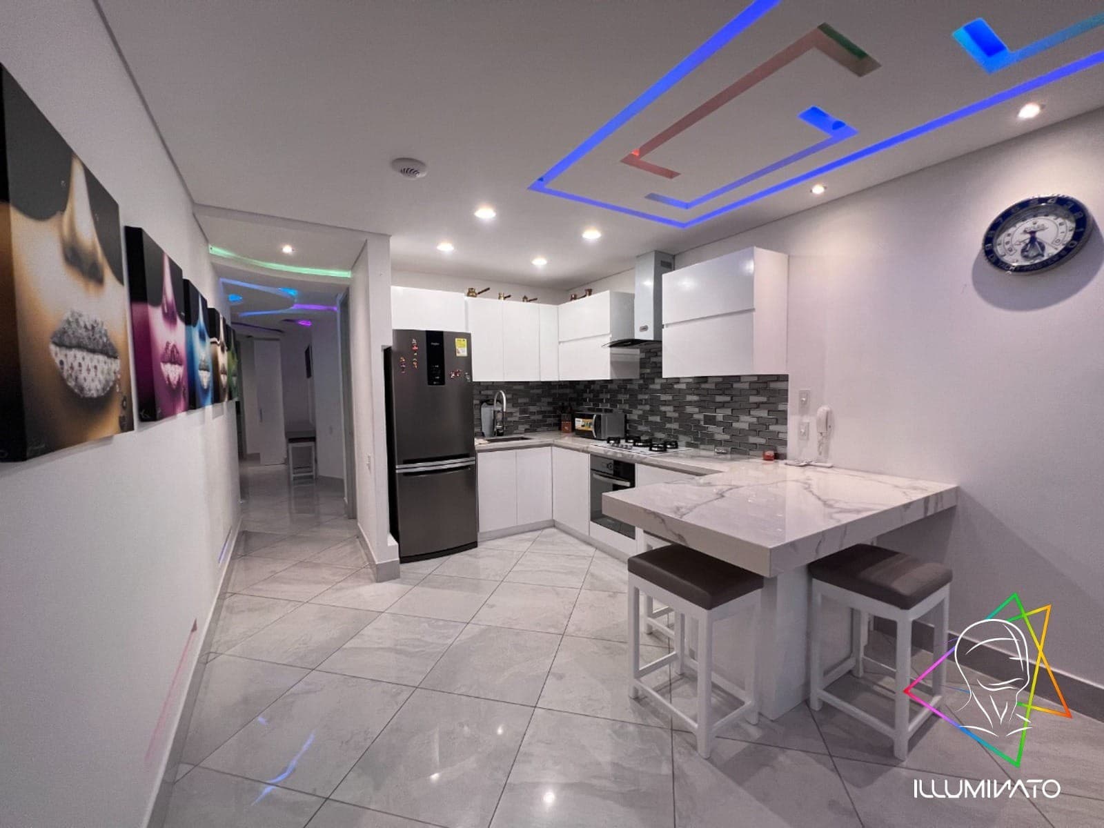 Cocina integral blanca con barra de comedor y electrodomésticos empotrados.