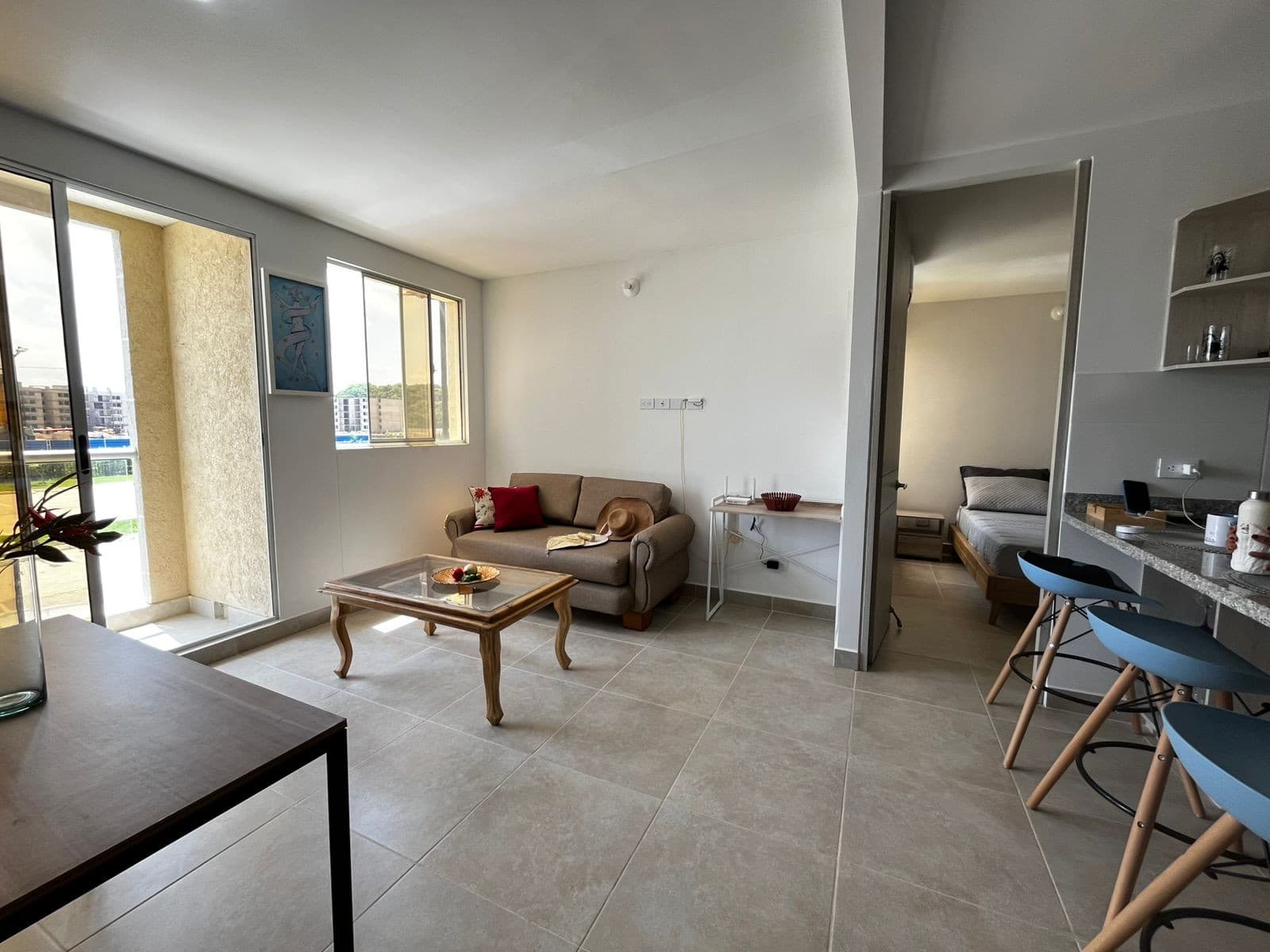 Sala con sofá y mesa de centro, vista desde el comedor.